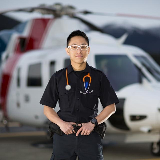 An air ambulance technician stands near a helicopter