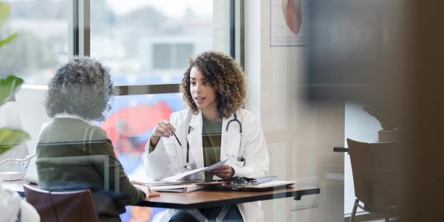 A doctor consults with a patient near a window