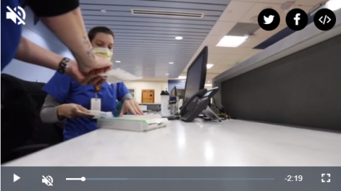 Video screenshot of two healthcare workers at a desk